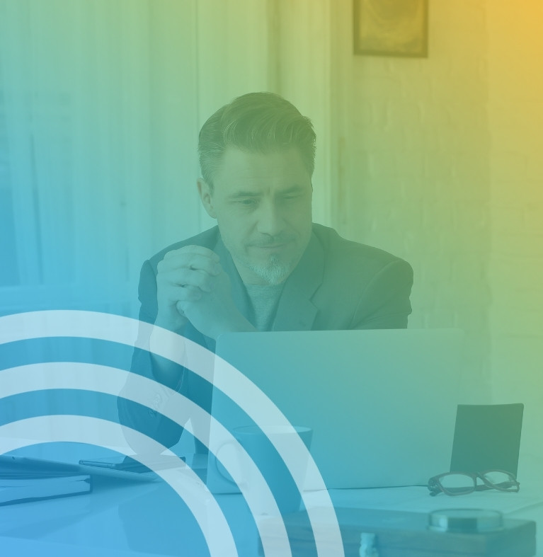 Man in a suit looking at a laptop with a blue to yellow gradient overlay