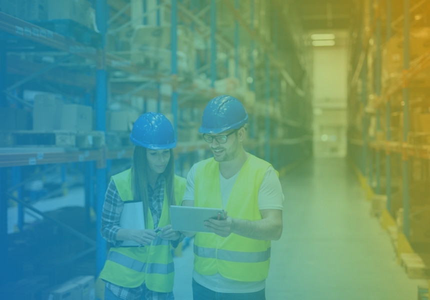 2 warehouse workers in hard hats with a tablet